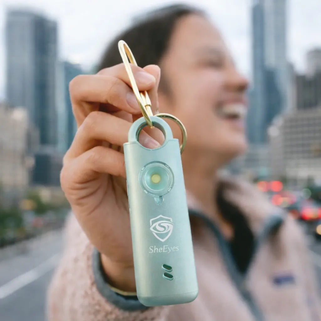 Woman holding SheEyes Pro safety alarm on hands