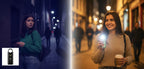 Two women on a city street at night, one with a flashlight SheEyes and the other with a phone, with a brand logo in the corner.